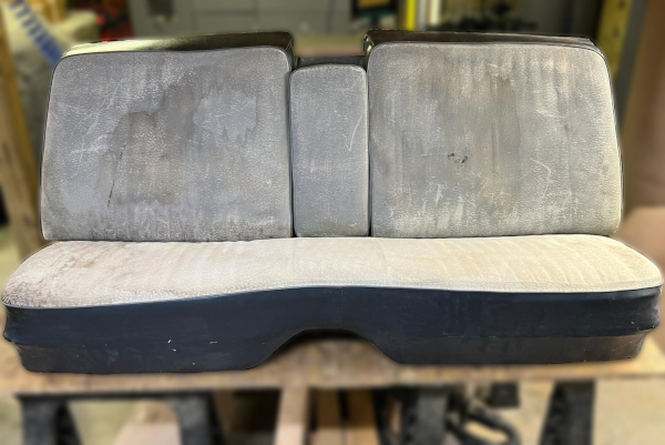 Before: Stained and deteriorating vehicle bench seat.