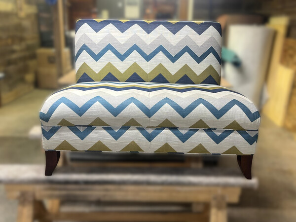 long-standing armless loveseat with threadbare antiquated covering
